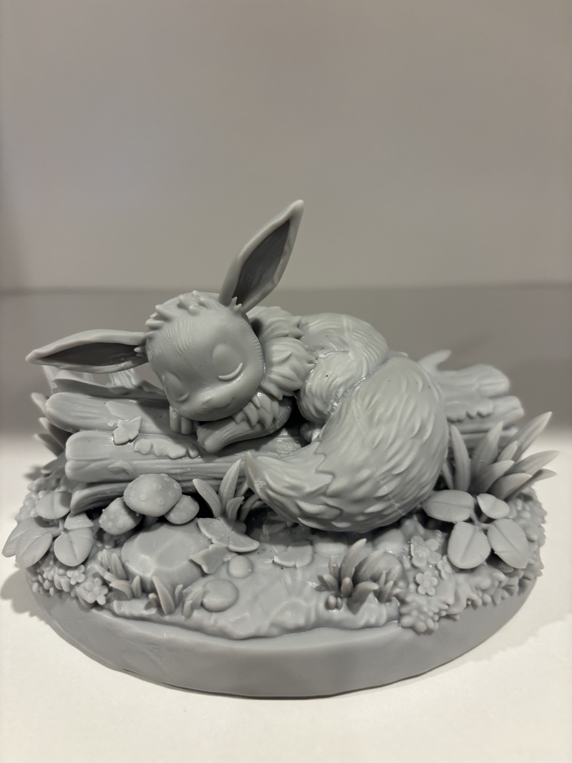 Unpainted sleeping character sculpture on a detailed woodland base